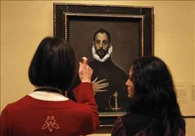 Dos jóvenes contemplan El caballero de la mano en el pecho, de El Greco