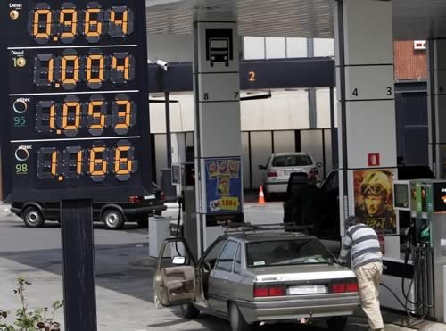 Un hombre reposta carburante en su coche en una estación de servicio.