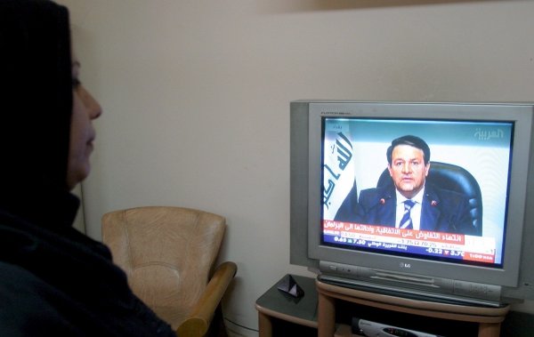 Una mujer sigue por televisión la rueda de prensa del portavoz del Gobierno, Ali al-Dabbaqh. (Foto: Mohammed Jalil)
