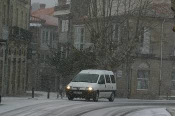 Un coche circula por una calle de Allariz, en medio de una intensa nevada. (Foto: José Paz)