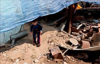 Dos niños palestinos observan un taller de metal destrozado por el impacto de un misil israelí al este de la ciudad de Gaza. (Foto: MOHAMMED SABER)