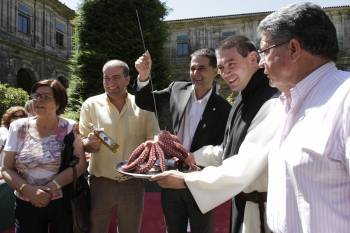 Gómez (izquierda), Carlos Montes (centro) y José Luis Valladares (derecha), bromean con el pulpo que sirve el abad de Oseira, Javier Martínez (Foto: Miguel Ángel)