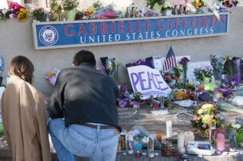 Un hombre y una niña rinden tributo en un santuario de apoyo a la congresista demócrata Giffords. (Foto: GARY M WILLIAMS)