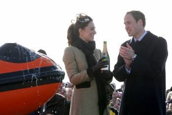 El príncipe Guillermo de Inglaterra aplaude después de que su prometida, Kate Middleton, vertiera el champán.