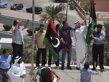  Kuwaitíes y libios enarbolan la bandera tricolor del consejo nacional de transición libio en la embajada libia en Kuwait, hoy, lunes 22 de agosto de 2011. Los choques entre los rebeldes y las tropas leales a Gadafi están sembrando el caos en la capital l