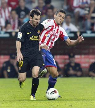 Leo Messi disputa la pelota con el delantero gaditano del Sporting Barral. (Foto: A. MORANTE)