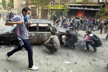  Manifestantes egipcios corren para huir del gas lacrimógeno durante un enfrentamiento con las fuerzas de seguridad del estado en la plaza Tahrir en El Cairo (Egipto)
