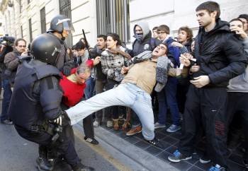 Los agentes antidisturbios forcejean con uno de los estudiantes que opone resistencia. (Foto: J.C. CÁRDENAS)