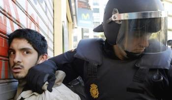 La policia custodia a un detenido durante los incidentes entre estudiantes y policias registrados hoy en el centro de Valencia. (Foto: EFE)