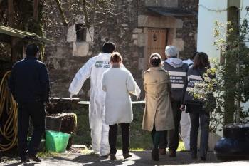 Agentes judiciales y forenses buscan pruebas en la parroquia de Burgas, donde aparecieron unos cuerpos en una casa familiar, y todos los indicios apuntan a un atraco en el que han muerto un hombre de 77 años y su hijo de 51 (Foto: efe)