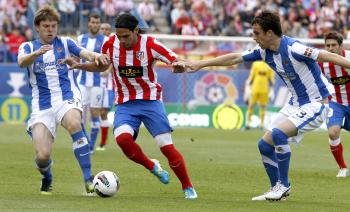 El delantero colombiano del Atlético de Madrid Radamel Falcao (c) controla la pelota ante la presencia de los jugadores de la Real Sociedad Mikel González  (Foto: EFE)
