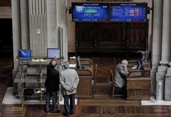 Dos inversores observan los paneles informativos ayer en la Bolsa de Madrid. (Foto: EMILIO NARANJO)