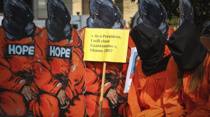 Activistas de Amnistía Internacional vestidos con el mono de los presos de Guantánamo protestan contra la visita de Obama