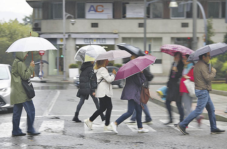 Estampa de viandantes con paraguas ayer en la ciudad.